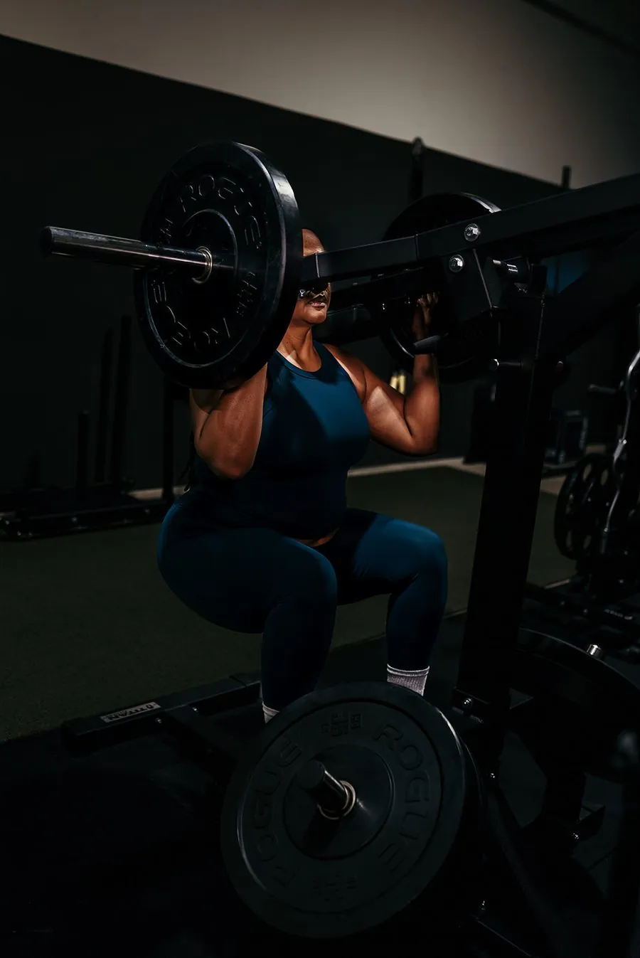 Client performing a barbell squat at Anew Training